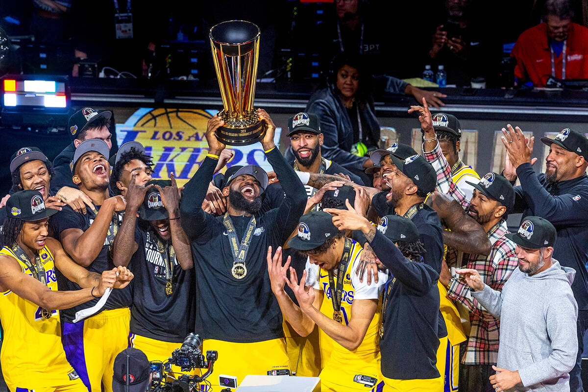 Los Angeles Lakers forward LeBron James (23) holds up the winning trophy about teammates after ...