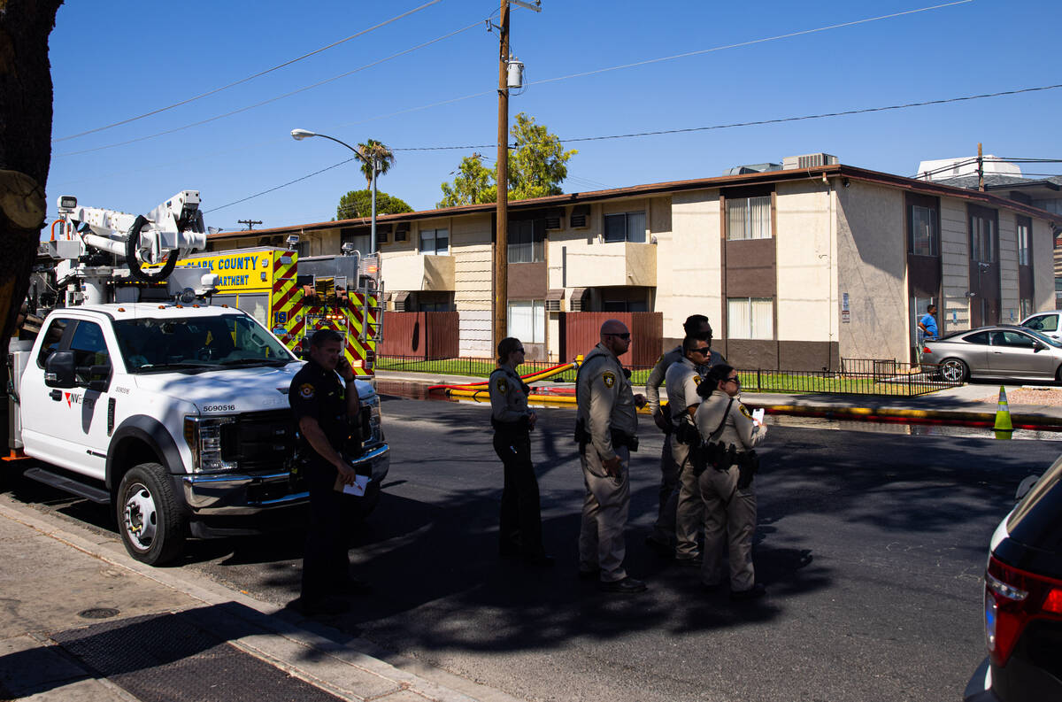 Las Vegas police look on as firefighters work to contain an apartment fire on Dumont Boulevard ...