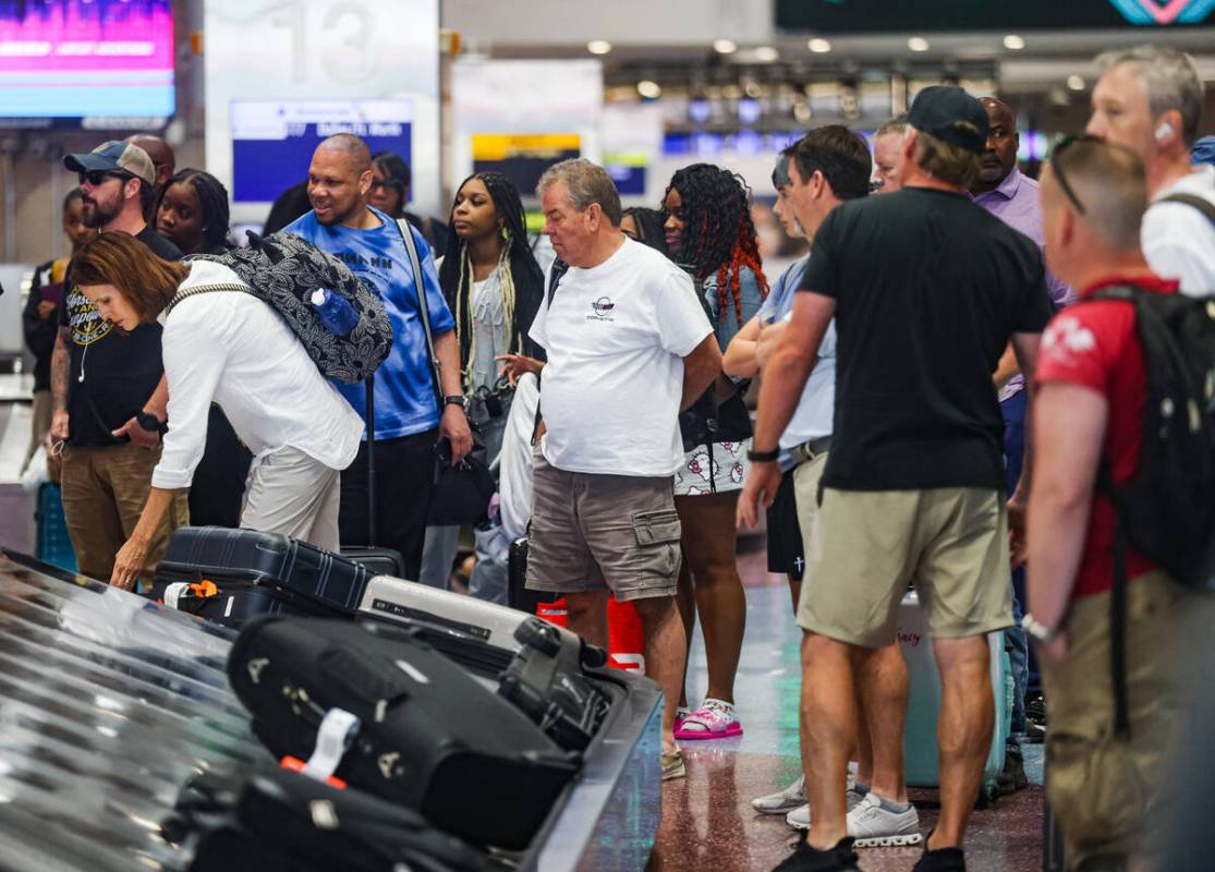 Guests wait for their luggage in the baggage claim area of Harry Reid International Airport in ...