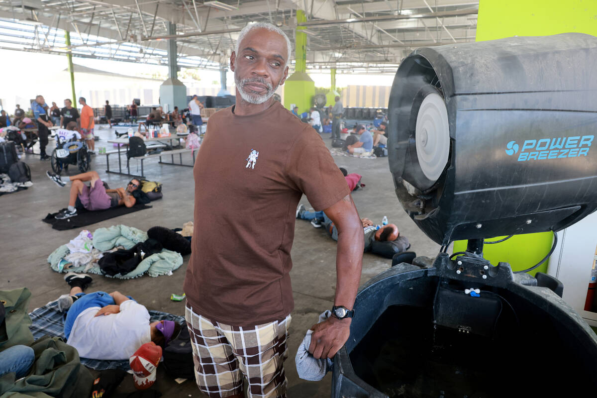 David West, 59, talks to a reporter in a cool mist at the Courtyard Homeless Resource Center in ...