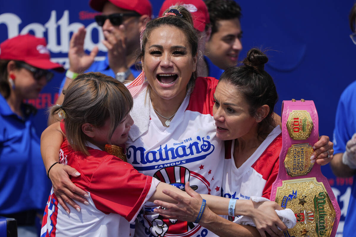 Miki Sudo, center, hugs Mayoi Ebihara, left, and Michelle Lesco, right, after winning the women ...