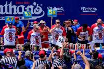 Patrick Bertoletti, center, competes in the men's division in Nathan's Famous Fourth of July ho ...