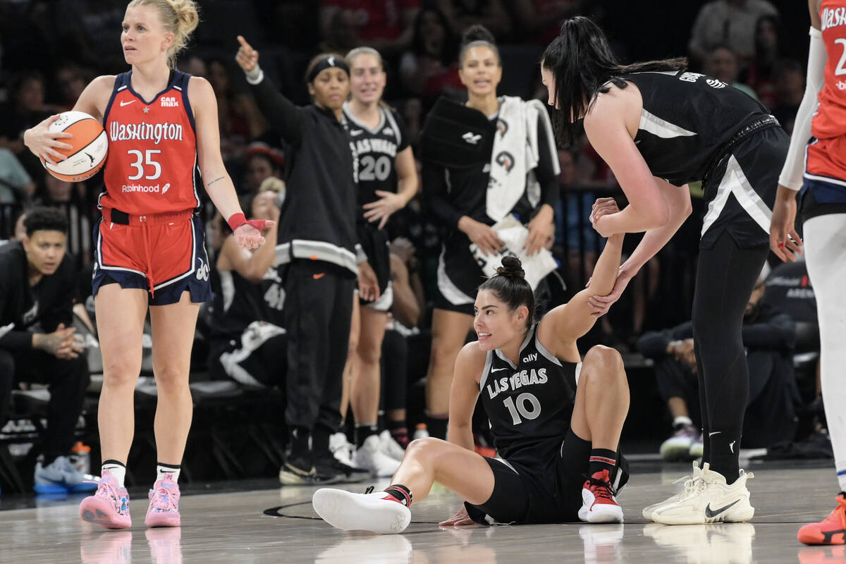 Las Vegas Aces guard Kelsey Plum (10) is helped up after being fouled by Washington Mystics gua ...