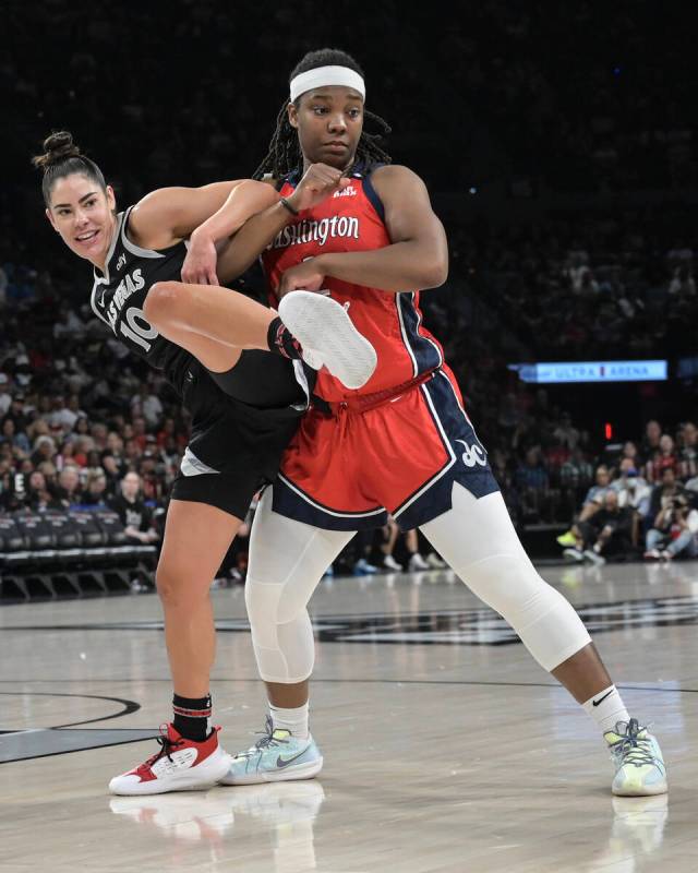 Las Vegas Aces guard Kelsey Plum (10) gets tangled up with Washington Mystics forward Myisha Hi ...