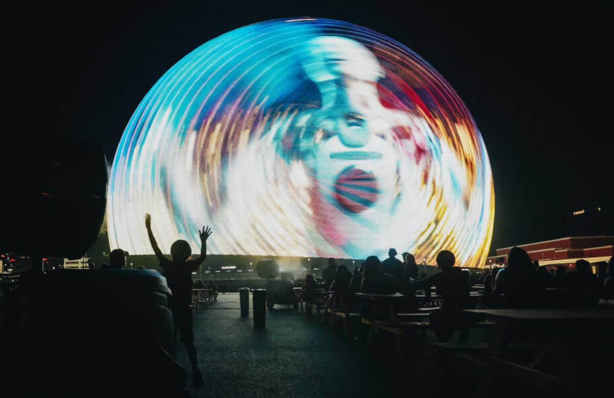 A child stays cool by a misting fan as the Sphere displays a show on Thursday, July 4, 2024, in ...