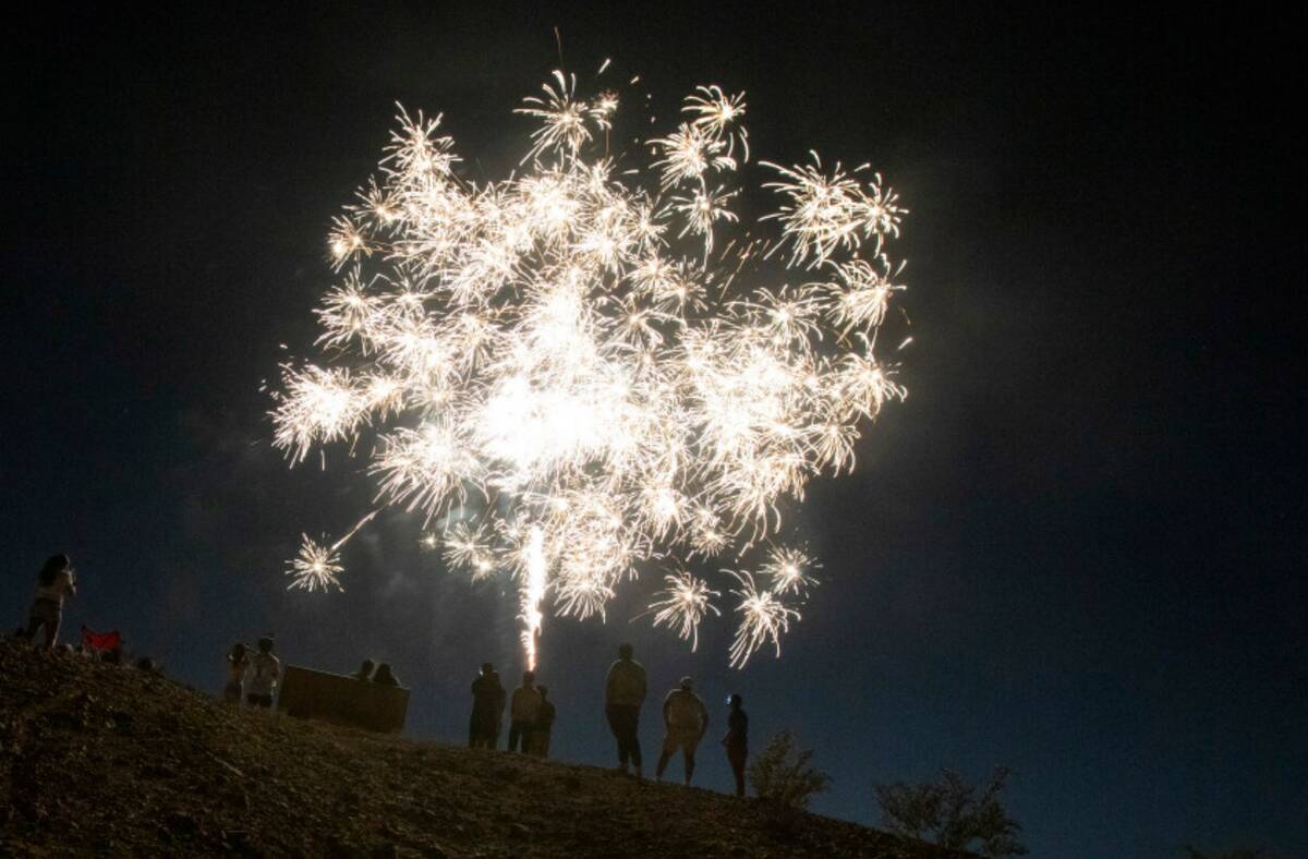 A small crowd watches a firework display near the Las Vegas Wash Thursday, July 4, 2024, in Hen ...