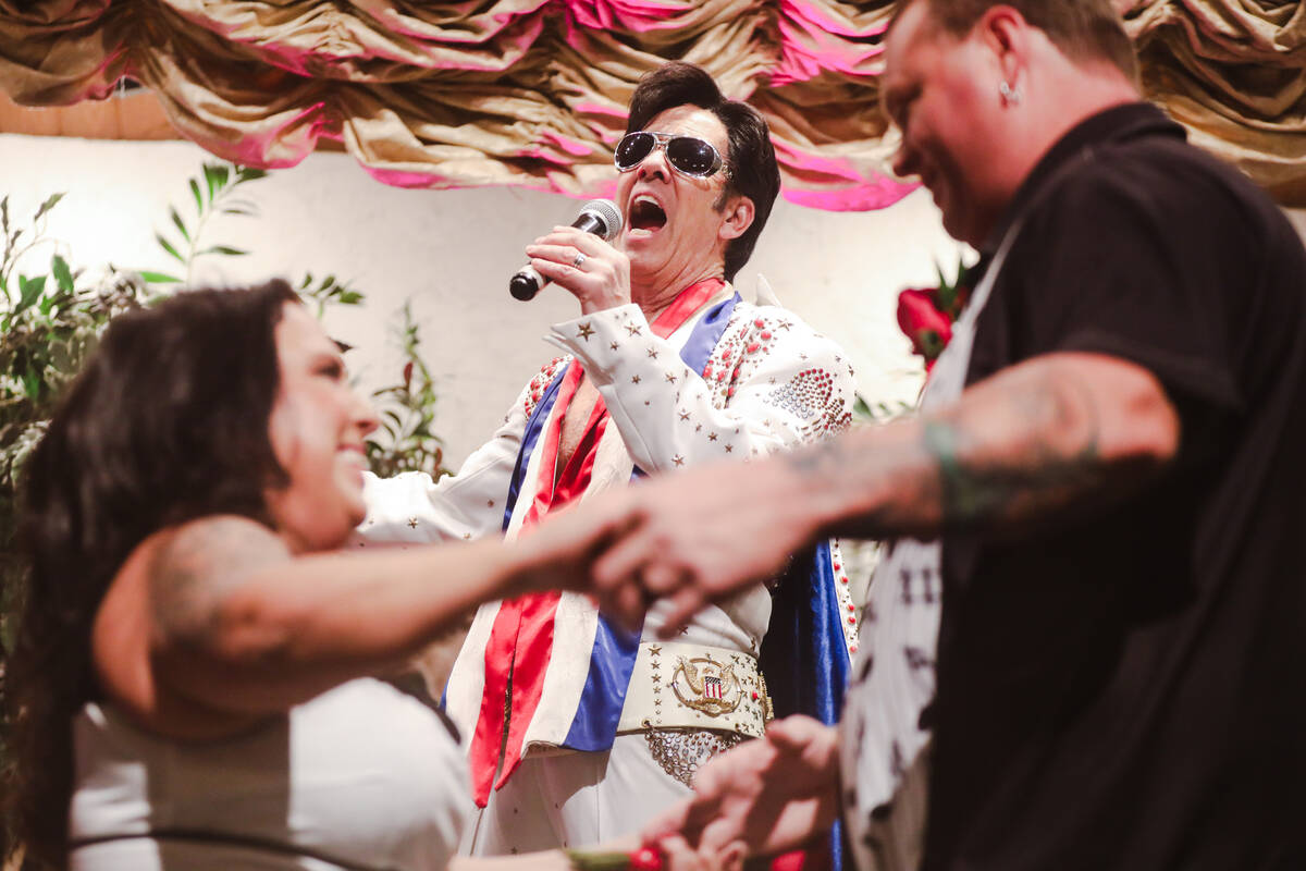 Karie Rockwood dances with Billy Traughber as Elvis impersonator Ron DeCar sings at their weddi ...