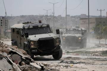 Israeli military vehicles maneuver during an operation in the West Bank city of Jenin, Friday, ...