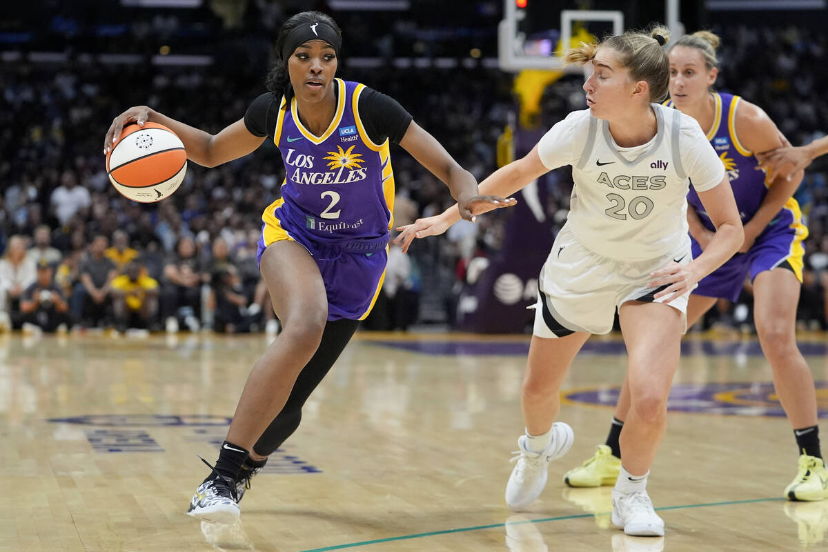 Los Angeles Sparks forward Rickea Jackson, left, drives against Las Vegas Aces guard Kate Marti ...