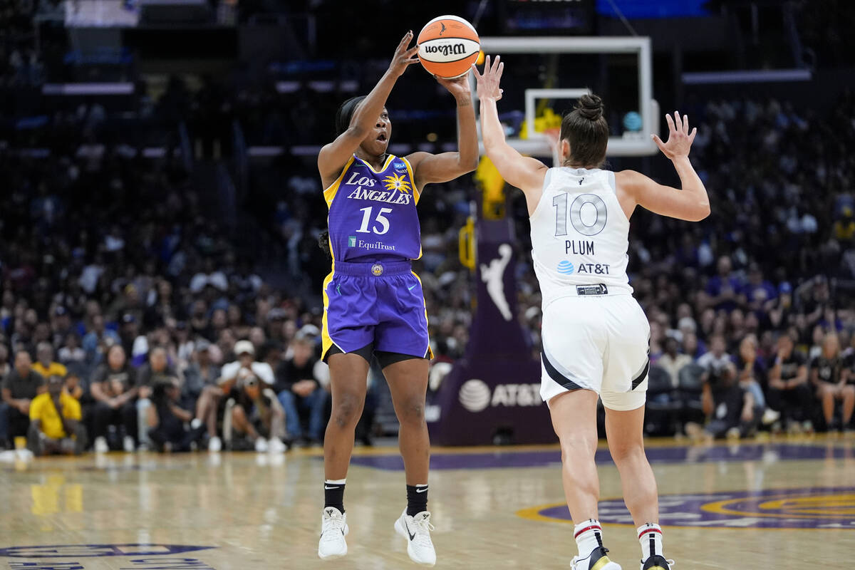 Los Angeles Sparks guard Aari McDonald, left, shoots against Las Vegas Aces guard Kelsey Plum d ...