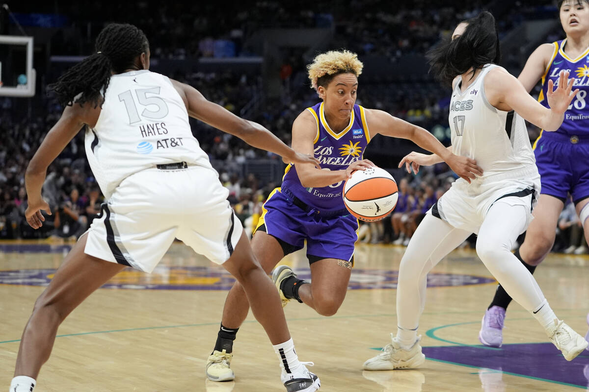 Los Angeles Sparks guard Layshia Clarendon, center, drives against Las Vegas Aces guard Tiffany ...