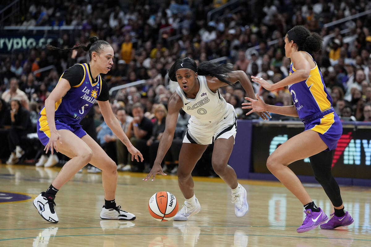 Las Vegas Aces guard Jackie Young (0) drives against Los Angeles Sparks forward Dearica Hamby, ...