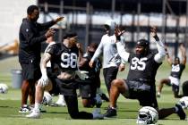 Raiders defensive end Maxx Crosby (98) and defensive tackle John Jenkins (95) chat with defensi ...
