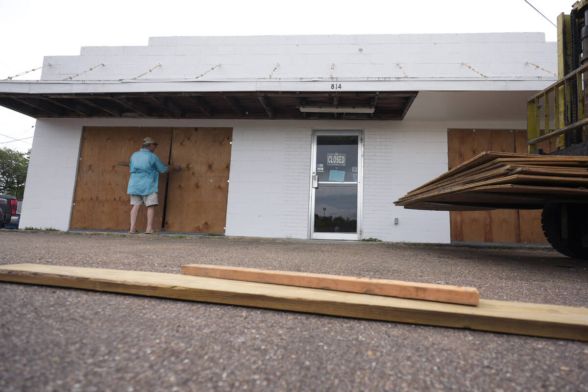 Jimmy May boards windows as he prepares for Beryl's arrival, Sunday, July 7, 2024, in Port Lava ...