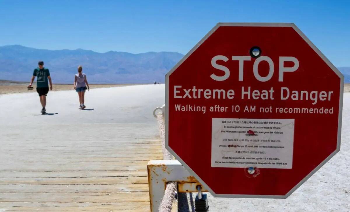 A sign warns people of extreme heat in multiple languages on July 11, 2023, in Death Valley Nat ...