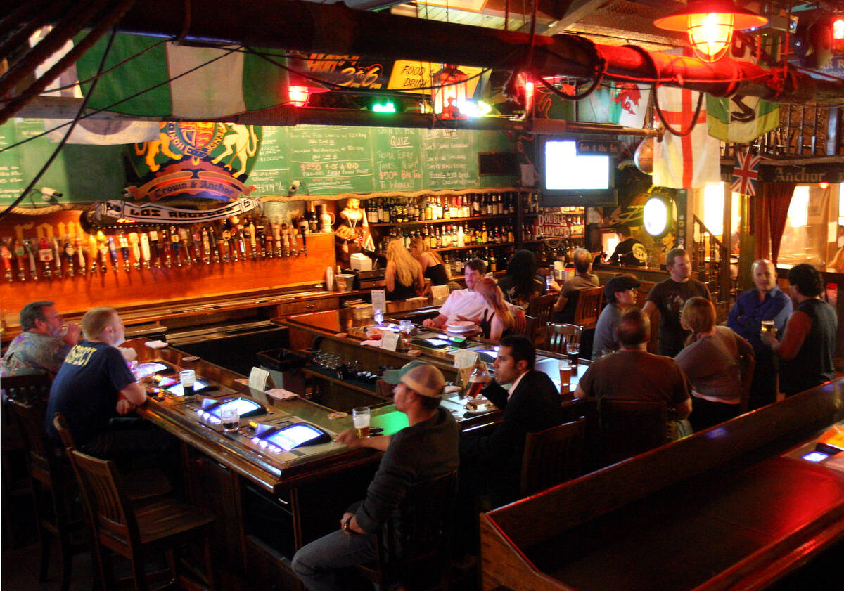 A crowd is gathered around the bar at the Crown & Anchor British Pub during happy hour Mond ...