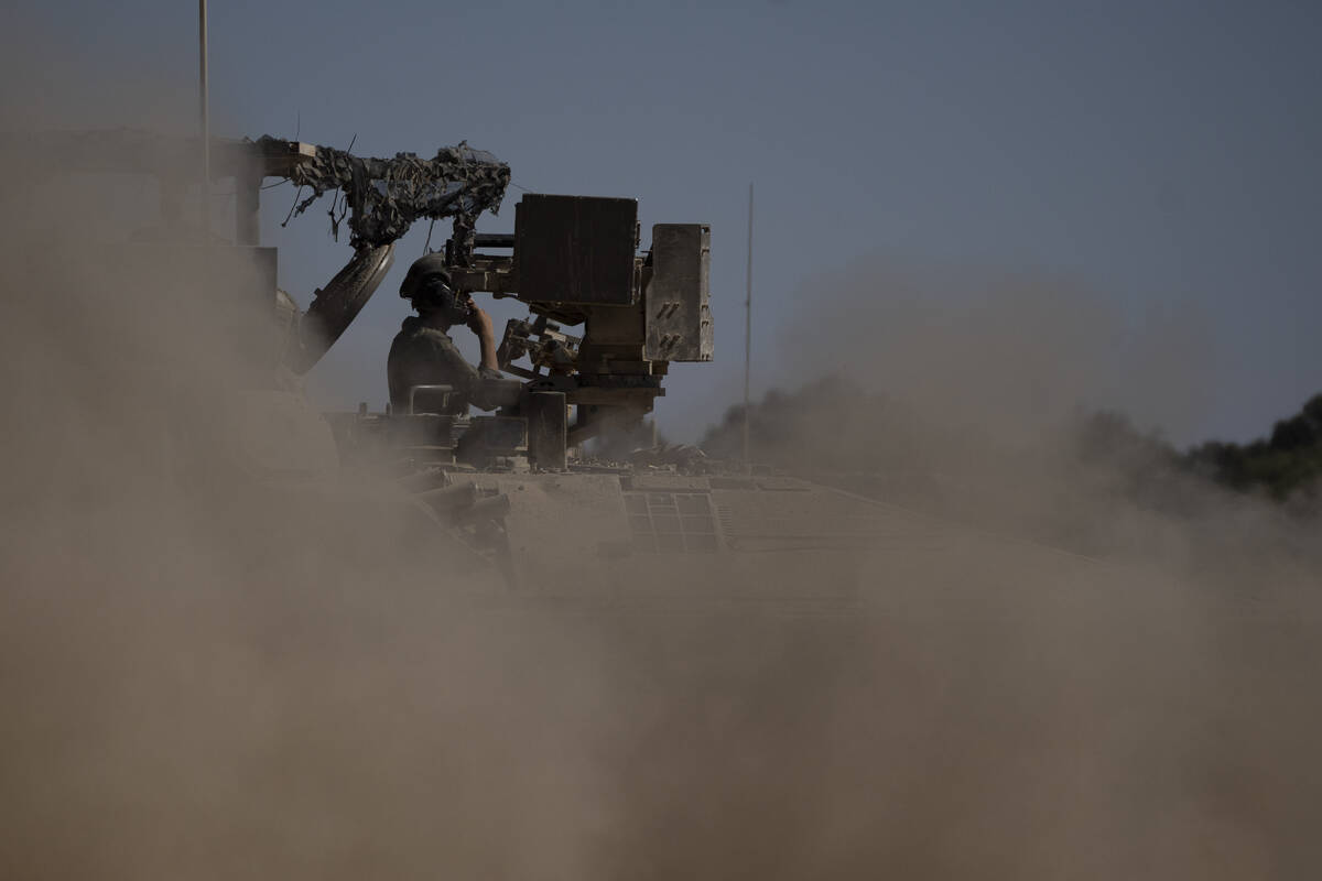 An Israeli soldier moves on an armoured personnel carriers (APC) near the Israeli-Gaza border, ...