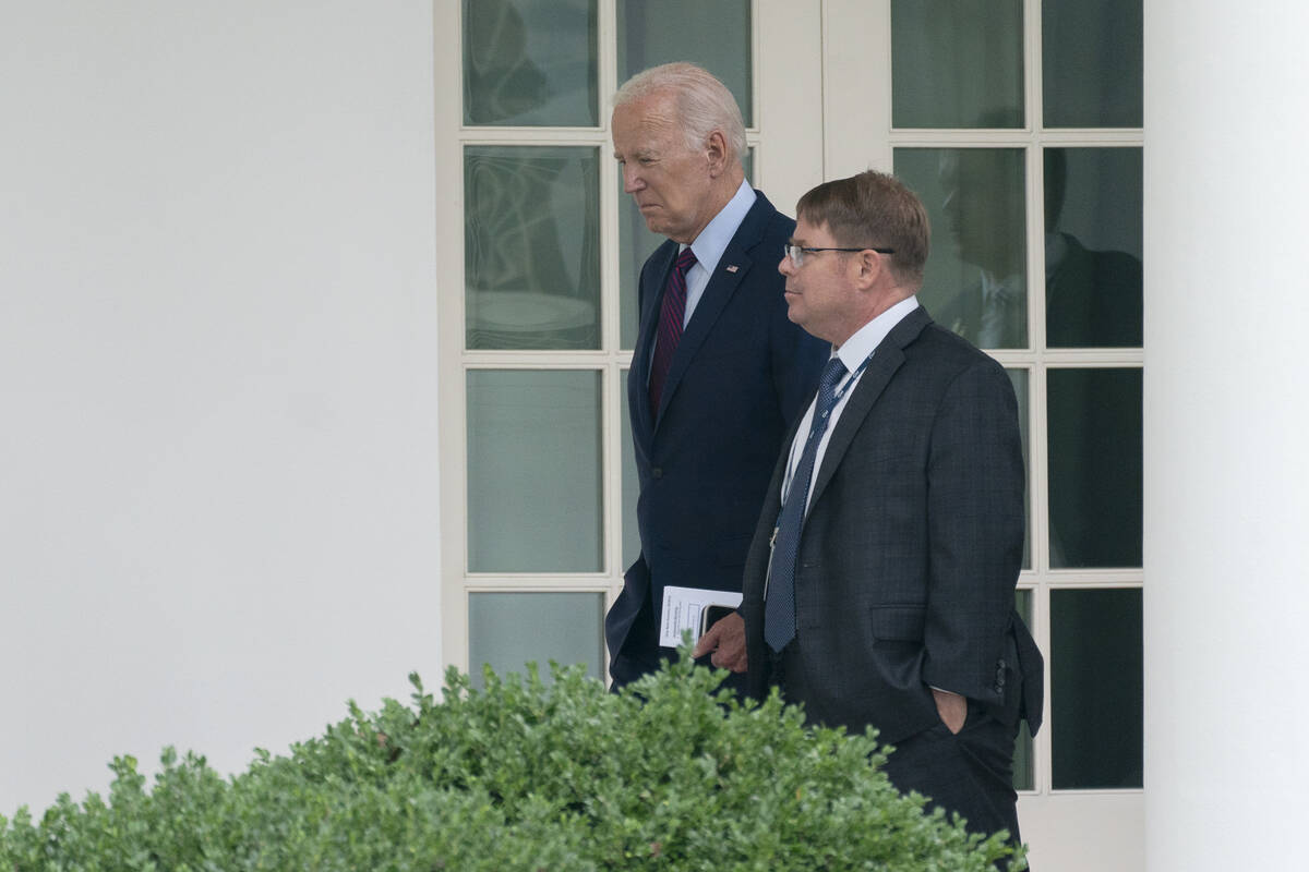 FILE - President Joe Biden walks along the Colonnade at the White House with his physician Kevi ...