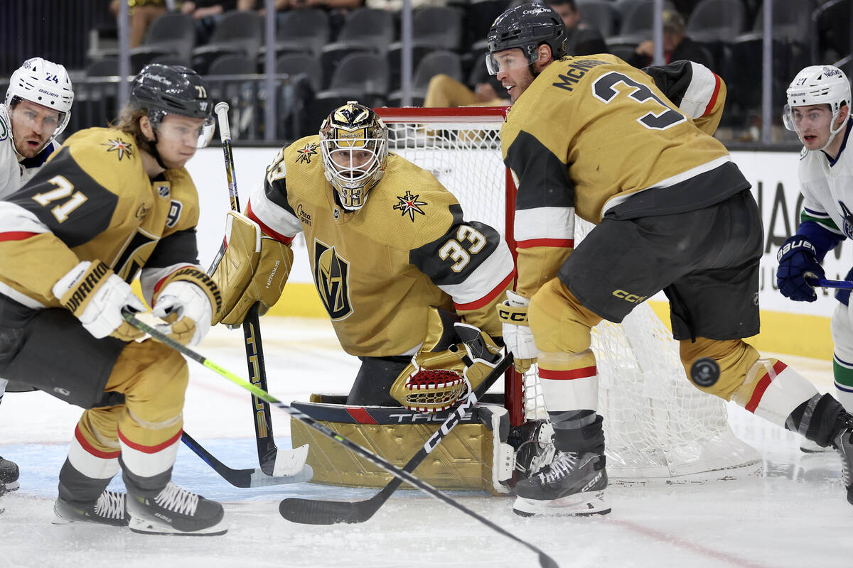 Golden Knights goaltender Adin Hill (33) watches the puck after a save while center William Kar ...