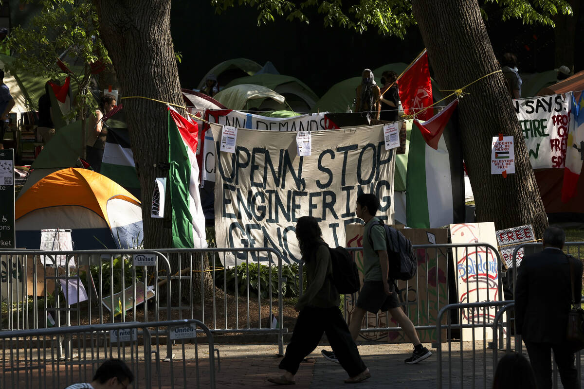 FILE - People walk past the Gaza Solidarity Encampment at the University of Pennsylvania in Phi ...