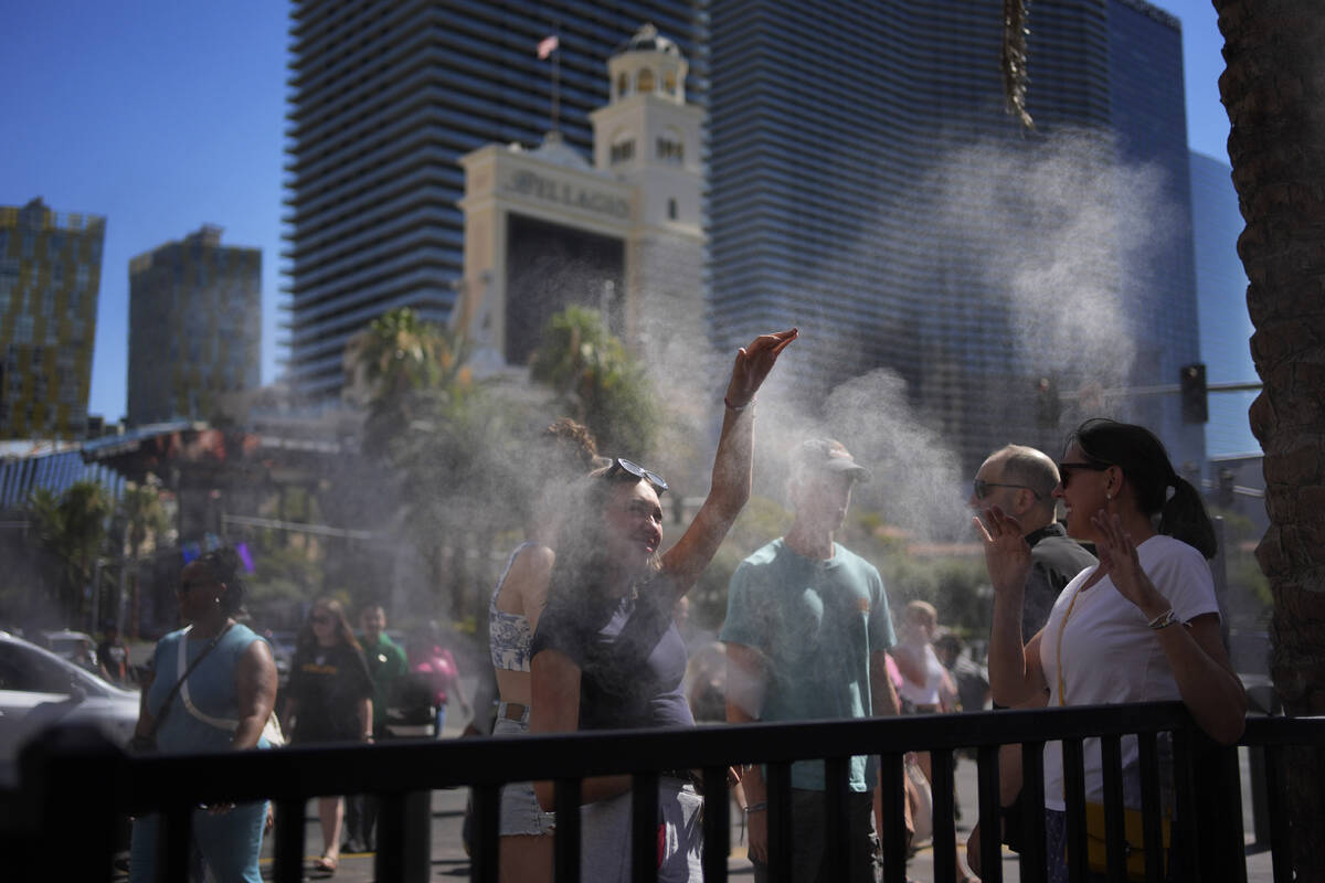 People cool off in misters along the Las Vegas Strip, Sunday, July 7, 2024, in Las Vegas. A hea ...