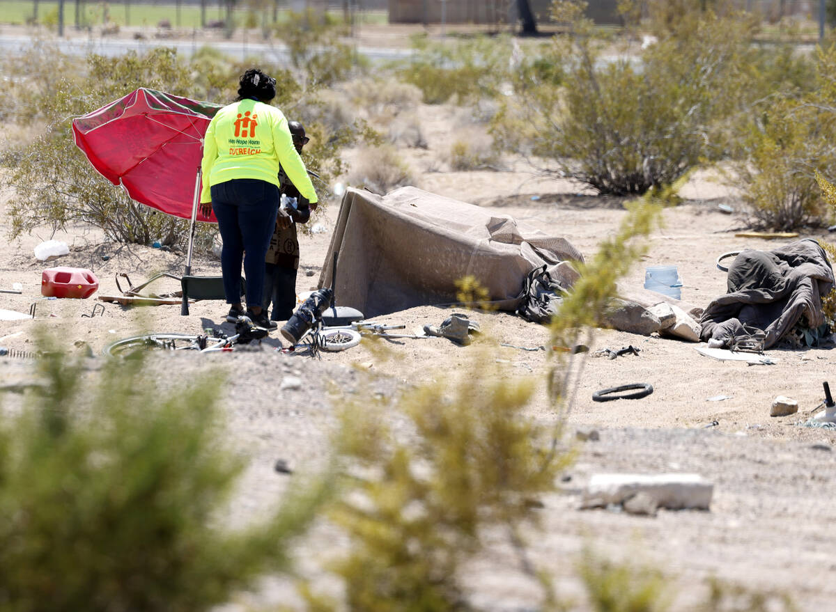 Zabrena Quinn, a Help of Southern Nevada outreach worker, delivers a case of water to Erik Smit ...