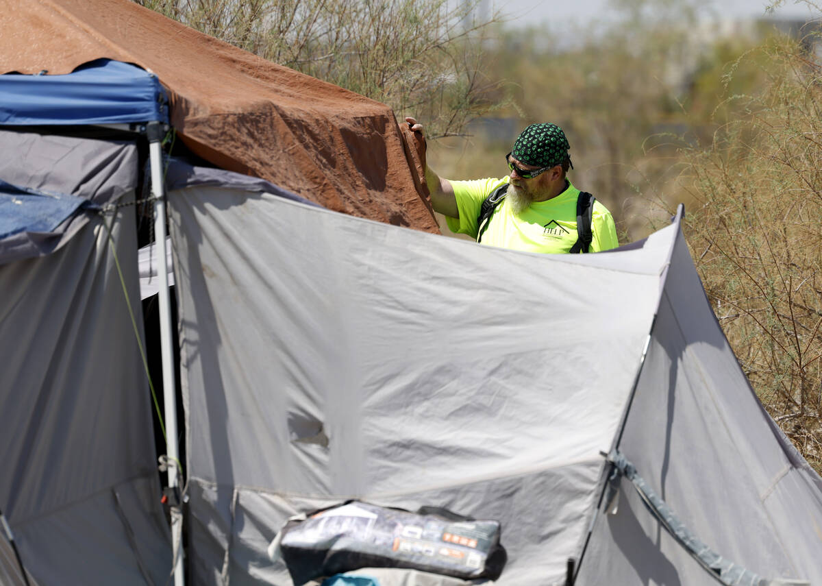 Chris Engel, a Help of Southern Nevada outreach worker, speaks to homeless people after deliver ...