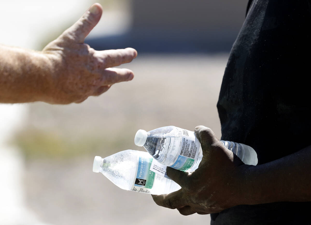 Darryl Walker, right, a homeless, talks to a Help of Southern Nevada outreach worker near Mount ...