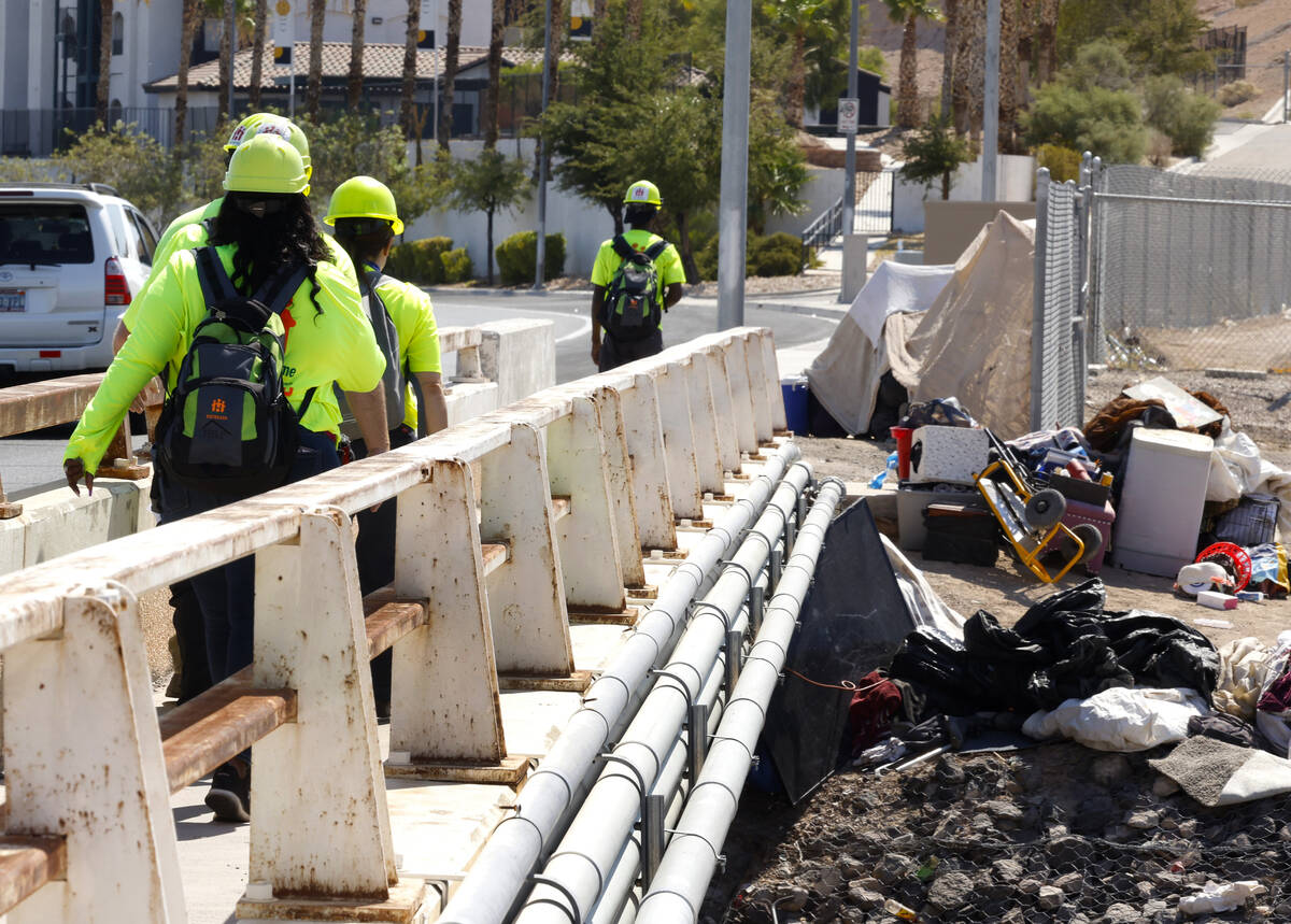 A Help of Southern Nevada outreach workers cross the bridge to check out homeless people near M ...