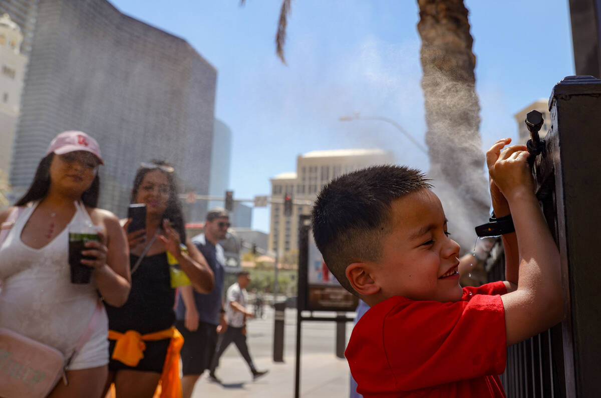 Josiah Ornelas, 6, cools down in front of misters outside Paris Las Vegas hotel-casino, Sunday, ...