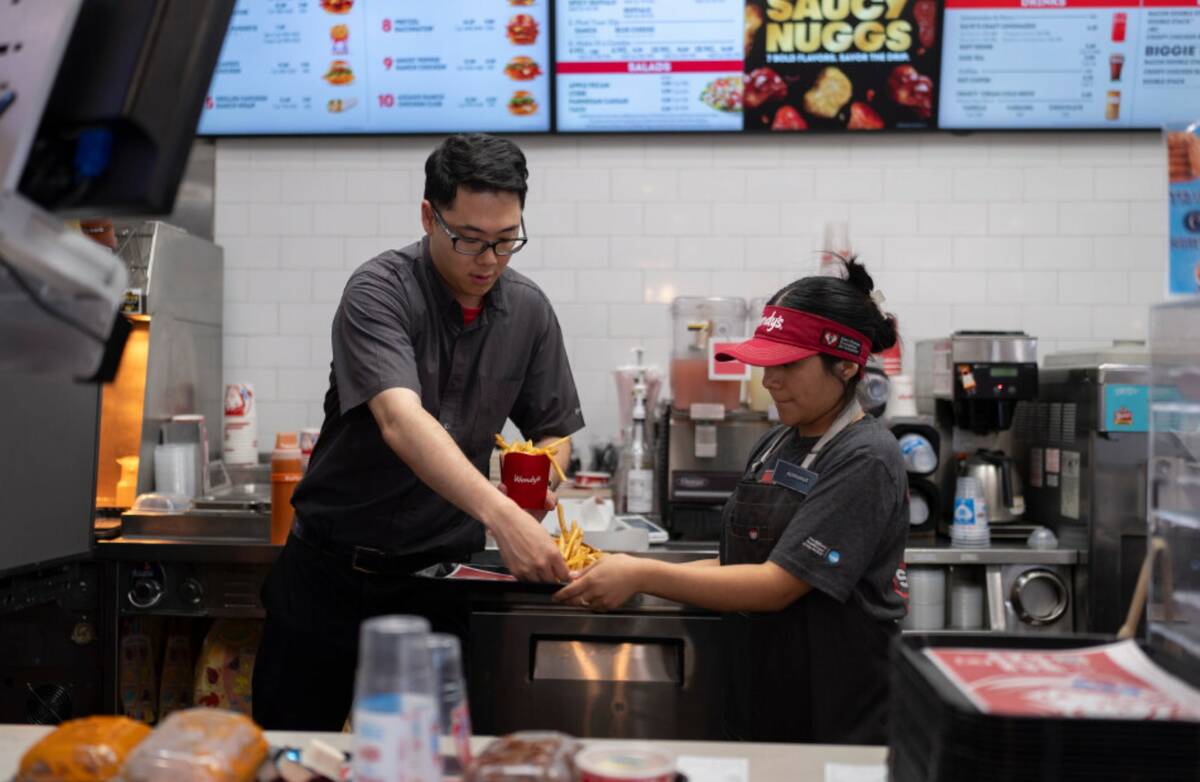 Lawrence Cheng, left, whose family owns seven Wendy's locations south of Los Angeles, works wit ...