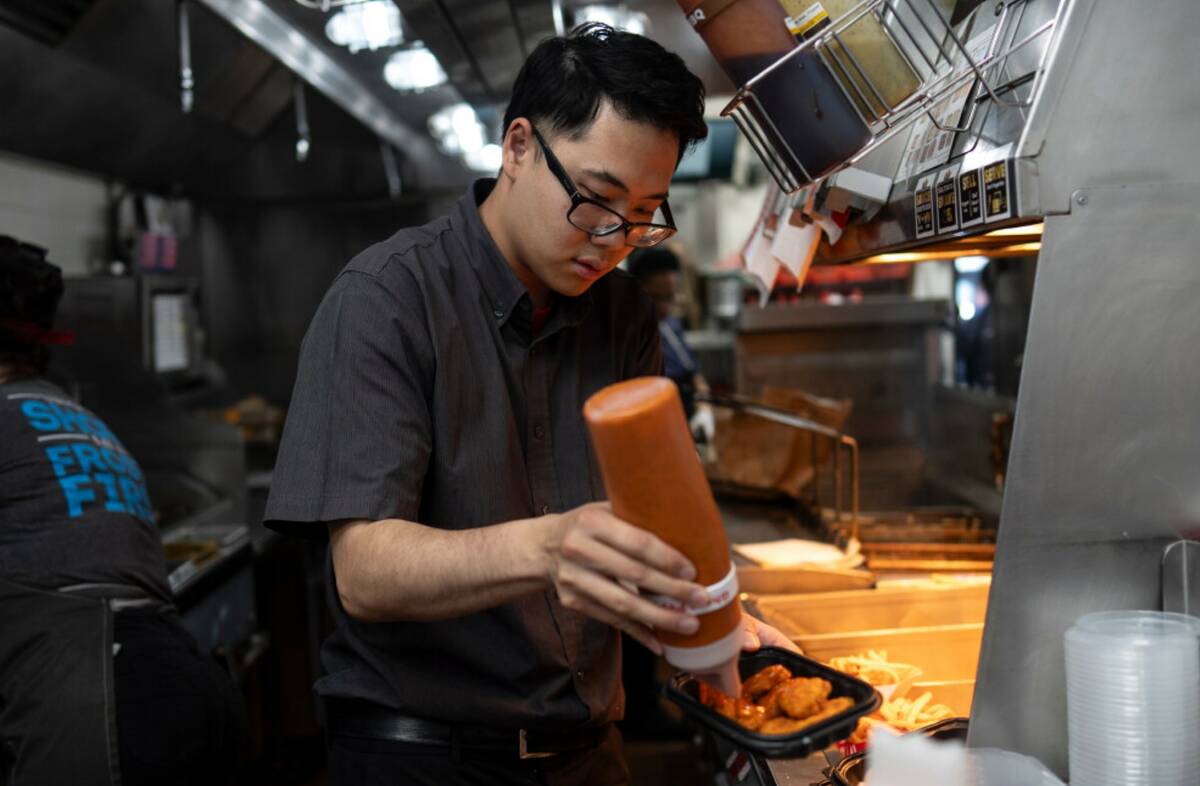 Lawrence Cheng, whose family owns seven Wendy's locations south of Los Angeles, works on an ord ...