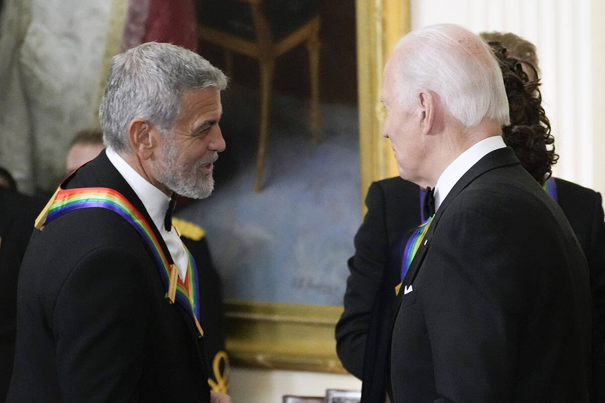 FILE - President Joe Biden shakes hands with actor, director and producer George Clooney during ...