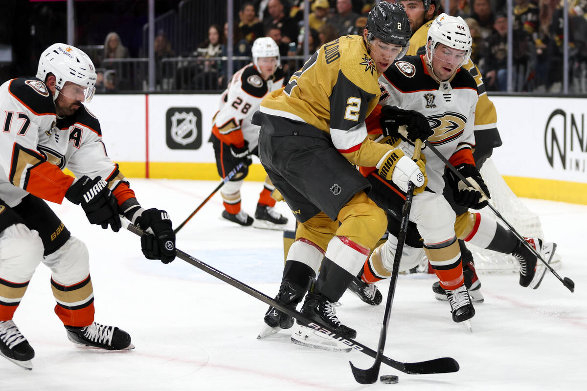 Golden Knights defenseman Zach Whitecloud (2) maneuvers the puck against Ducks left wing Alex K ...