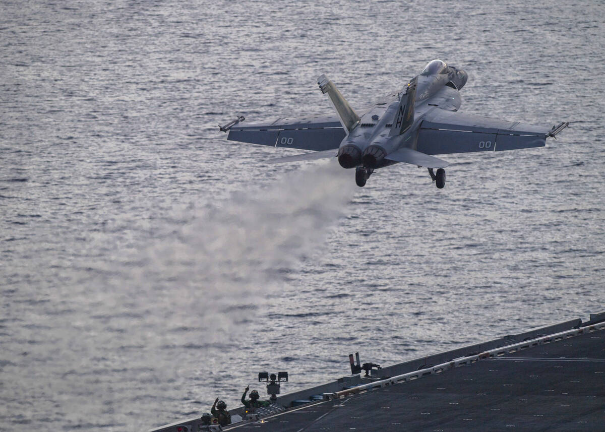 In this photograph released by the U.S. Navy, an F/A-18 Super Hornet launches off the flight de ...