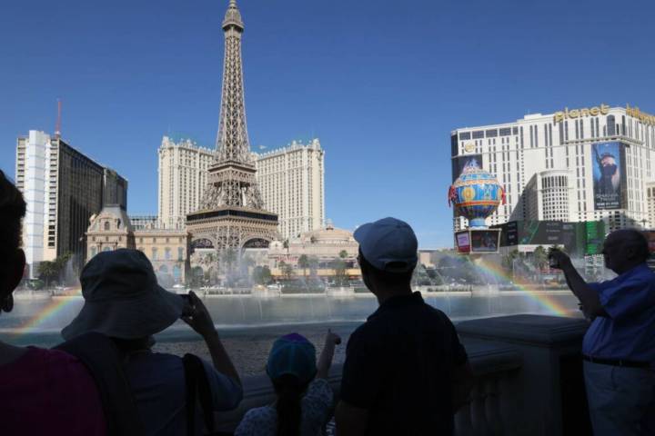 Visitors to the Las Vegas Strip view the Bellagio Fountains from the shade during high temperat ...