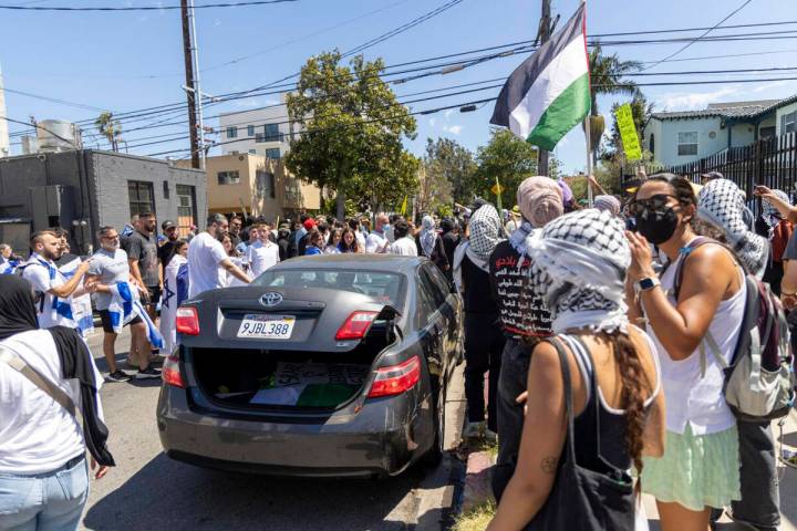 Pro-Palestine protester gets in car that is being swarmed by Pro-Israel protesters near Adas To ...