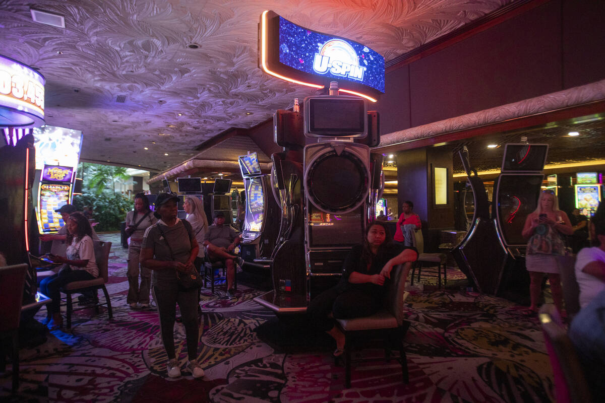 Tourists sit at old slot machines, waiting for a usable one to open up, in The Mirage, Wednesda ...