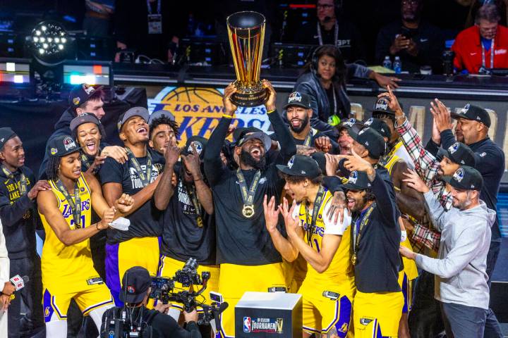 Los Angeles Lakers forward LeBron James (23) holds up the winning trophy about teammates after ...