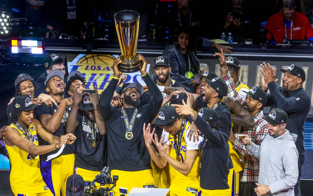 Los Angeles Lakers forward LeBron James (23) holds up the winning trophy about teammates after ...