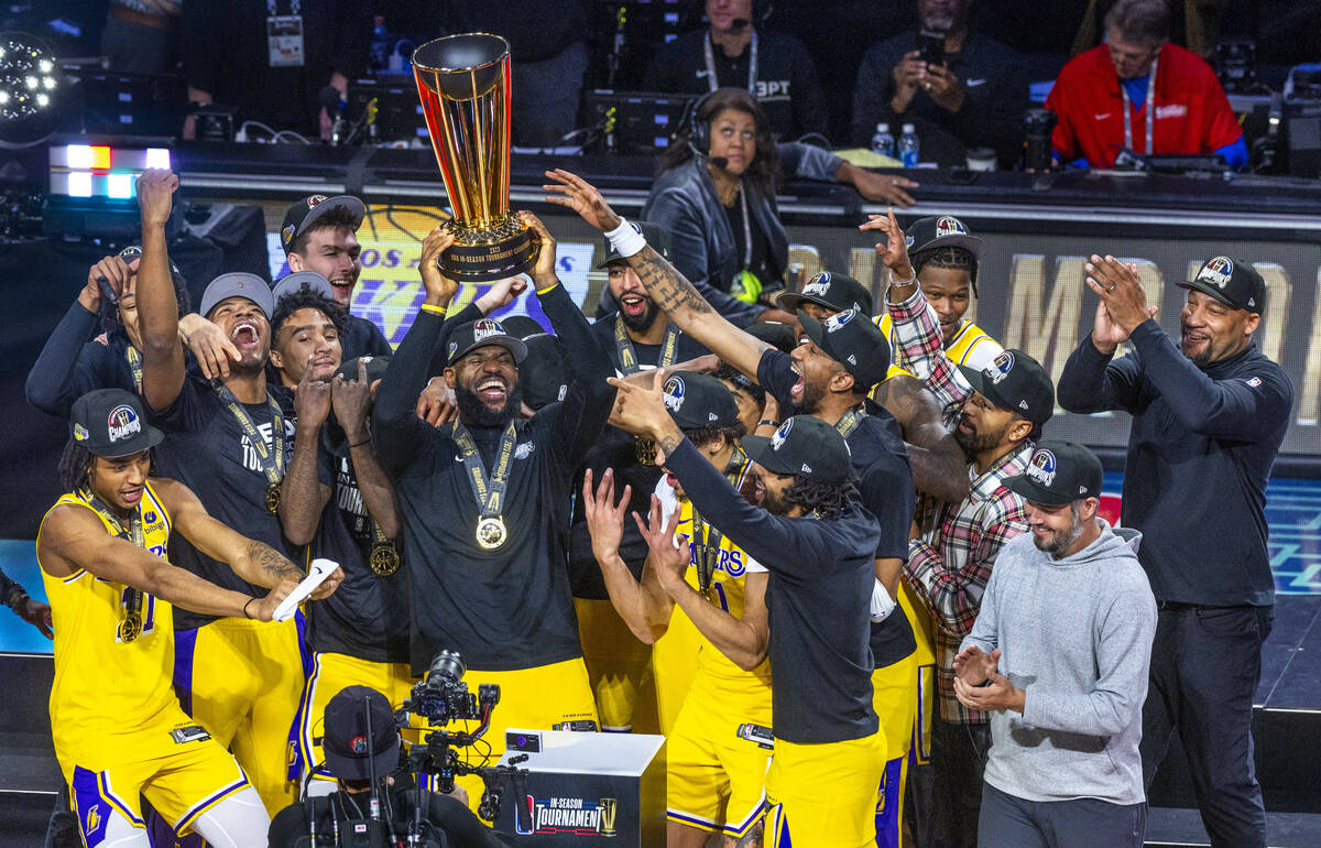 Los Angeles Lakers forward LeBron James (23) holds up the winning trophy about teammates after ...