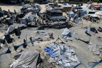 Palestinians inspect the damage at a site hit by an Israeli bombardment on Khan Younis, souther ...