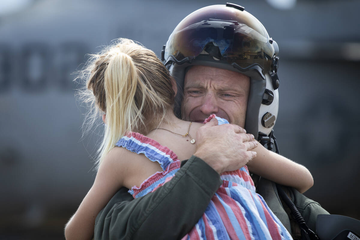 Commander Andrew "Sugar" Stoner reacts as he holds his daughter Katherine Stoner, 7, ...