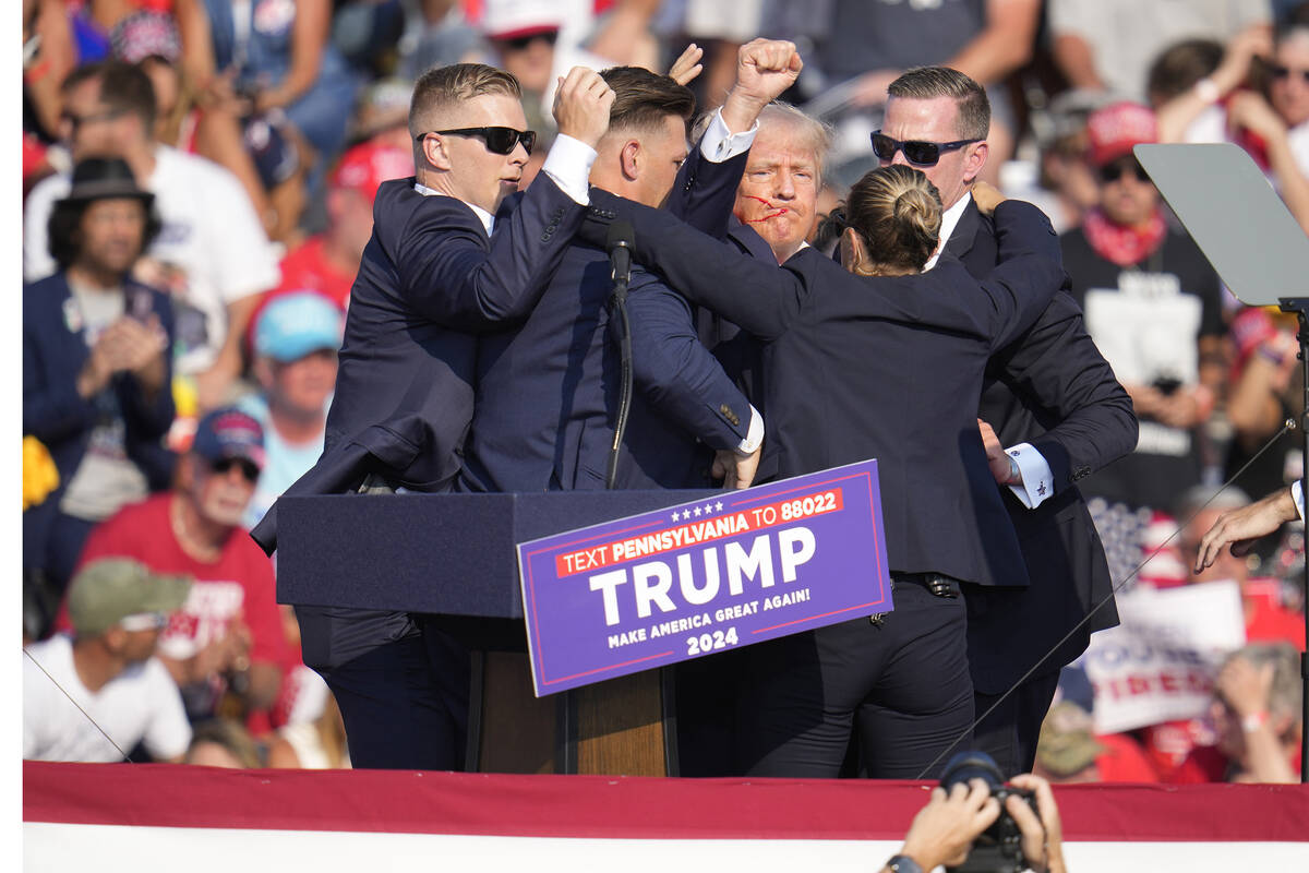 Republican presidential candidate former President Donald Trump is helped off the stage at a ca ...