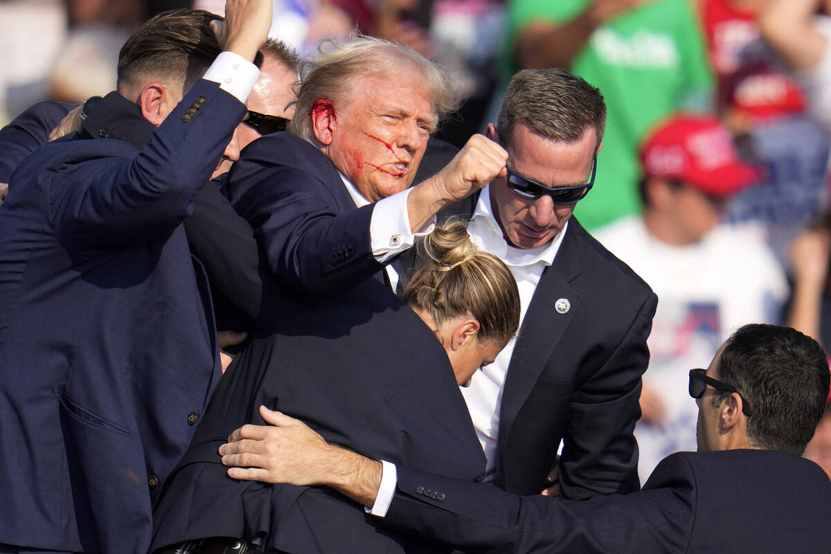 Republican presidential candidate former President Donald Trump is helped off the stage by U.S. ...