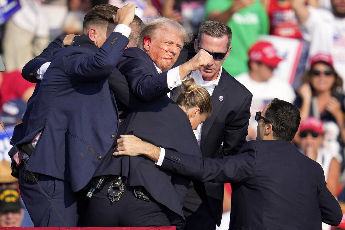 Republican presidential candidate former President Donald Trump is helped off the stage by U.S. ...