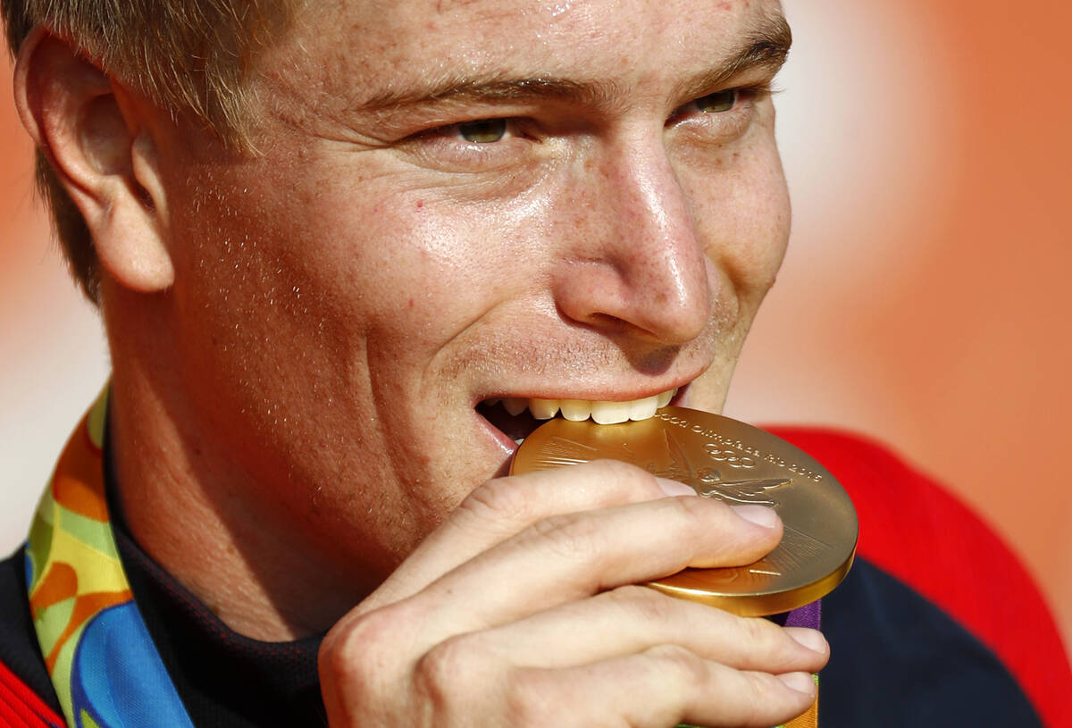 FILE - Connor Fields, of the United States, bites his gold medal during a victory ceremony for ...