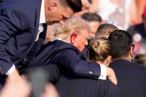 Republican presidential candidate former President Donald Trump is helped off the stage at a ca ...