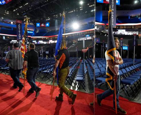 Members of an honor guard are reflected in a mylar wall, left, during a rehearsal for the 2024 ...