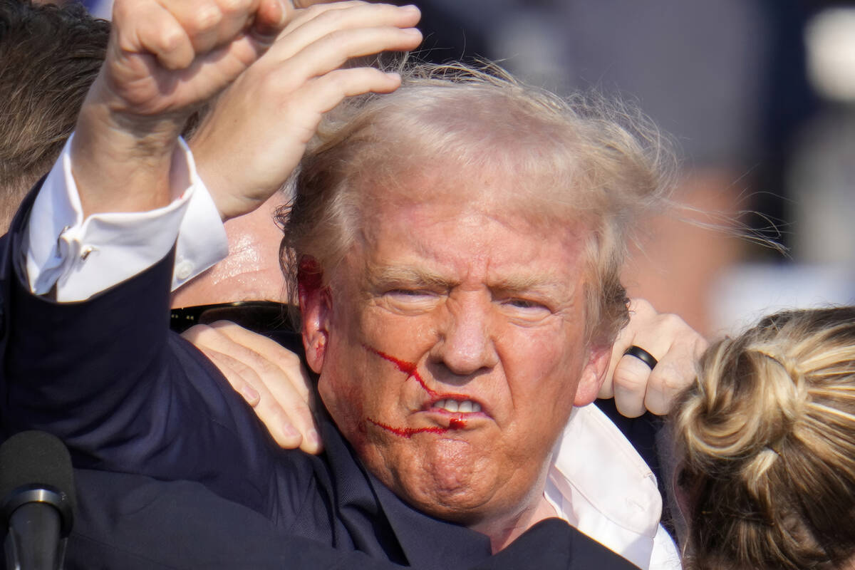 Republican presidential candidate former President Donald Trump gestures as he is surrounded by ...